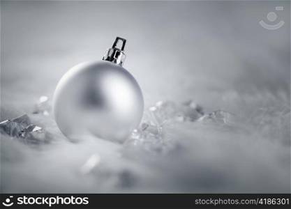 christmas silver bauble on fur snow and ice cold winter