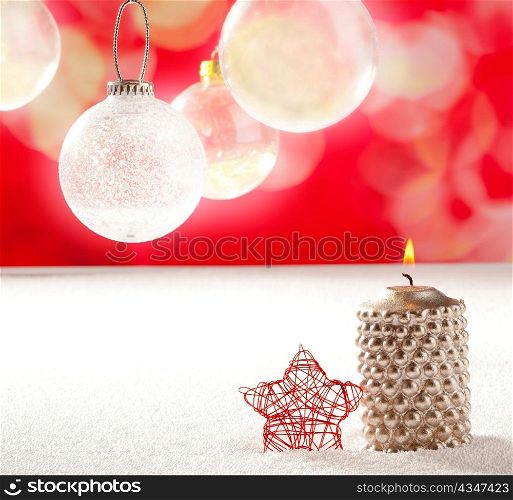 christmas silver candle and red star on snow and red with glass baubles