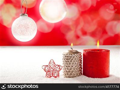 christmas silver red candles and star on snow with glass baubles