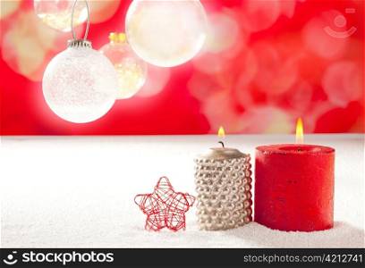 christmas silver red candles and star on snow with glass baubles