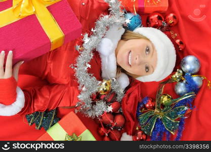 Christmas smiling woman in red santa cap with a gift.