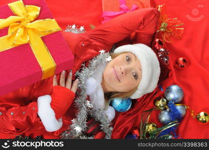 Christmas smiling woman in red santa cap with a gift.