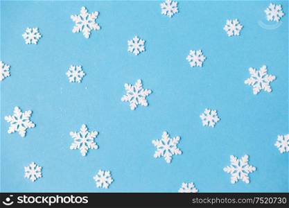 christmas, snow and winter holidays concept - white snowflake decorations on blue background. white snowflake decorations on blue background