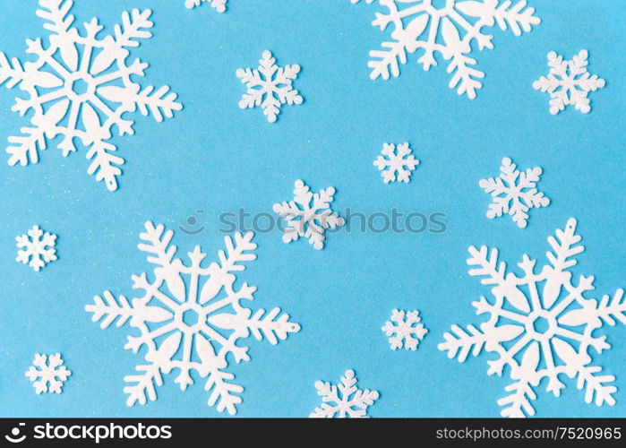 christmas, snow and winter holidays concept - white snowflake decorations on blue background. white snowflake decorations on blue background