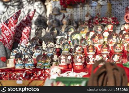 Christmas snow globe balls with snow man, santa clause and christmas trees inside out of glass on a christmas market booth in meran in South tyrol Italy