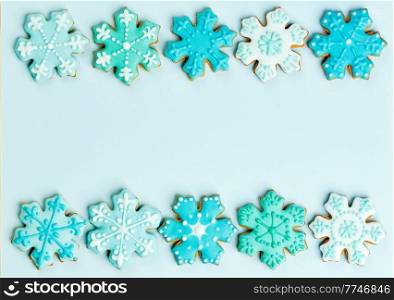 Christmas snowflake cookies set. Isolated ginger cookies with decoration on blue background. Sweet and delicious holiday gift. Christmas card