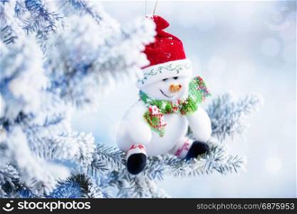 Christmas Snowman Hanging on a Tree Branch in the Snow Winter Forest