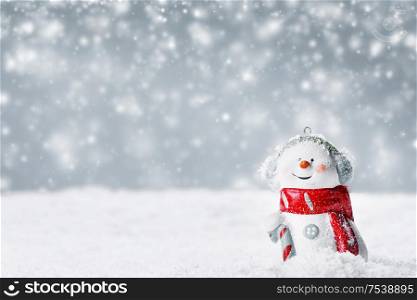 Christmas Snowman toy on winter background in the snow. Snowman toy on winter background