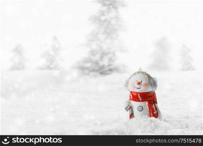 Christmas Snowman toy on winter forest background in the snow. Snowman toy on winter background