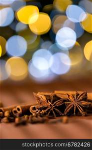 Christmas spices clove, star anise and cinnamon sparkling lights background