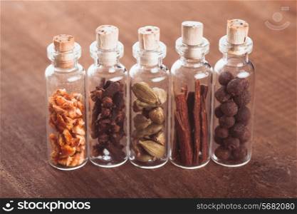 Christmas spices for mulled wine or ginger cookies in small decorative bottles