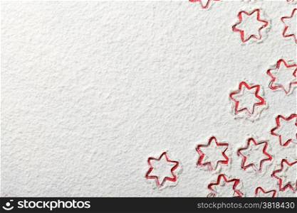 Christmas stars on flour background with copy space. White flour looks like snow. Top view