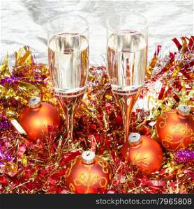 Christmas still life - above view of two glasses of champagne with orange Xmas decorations on gold background