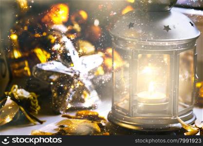 Christmas still life: lantern with burning candle and New Year tree decorations. Shallow depth of field