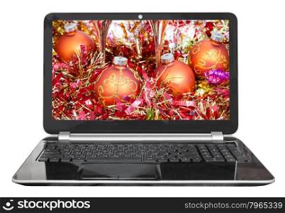 Christmas still life with orange baubles on screen of laptop isolated on white background
