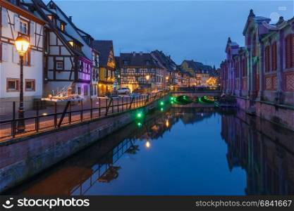 Christmas street at night, Colmar, Alsace, France. Traditional Alsatian half-timbered houses on the channel in Petite Venise, old town of Colmar, decorated and illuminated at christmas time, Alsace, France