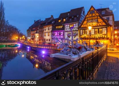 Christmas street at night, Colmar, Alsace, France. Traditional Alsatian half-timbered houses on the channel in Petite Venise, old town of Colmar, decorated and illuminated at christmas time, Alsace, France