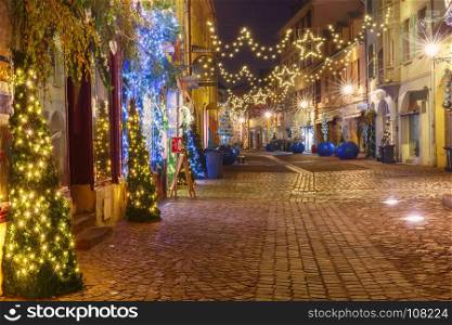Christmas street at night in Colmar, Alsace, France. Traditional Alsatian half-timbered houses in old town of Colmar, decorated and illuminated at christmas time, Alsace, France