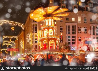 Christmas street at night in Dresden, Germany. Decorated and illuminated Christmas street with carousel at snowy christmas night in Dresden, Saxony, Germany