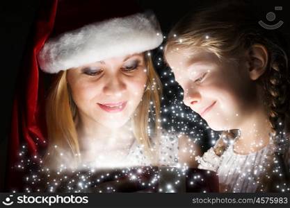 Christmas surprise. Happy daughter receiving Christmas gift from mother