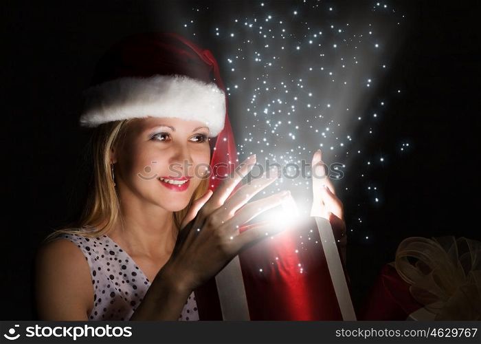 Christmas surprise. Happy woman in santa hat opening Christmas gift box