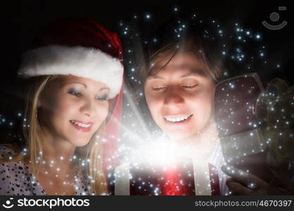 Christmas surprise. Man presenting to woman red gift box