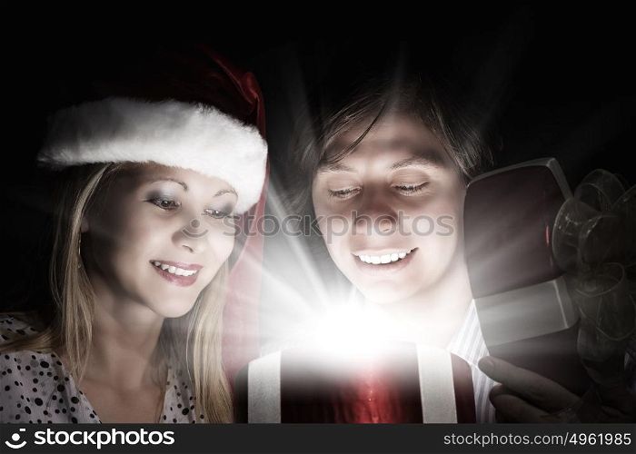 Christmas surprise. Man presenting to woman red gift box