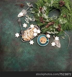 Christmas sweet food star cookies, cake Stollen, coffee and decoration. Holidays background turquoise stone. Vintage style toned picture