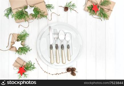 Christmas table place setting decoration. Plate with fork and knife. Top view