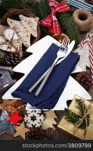 Christmas table place setting with christmas decorations on wooden table