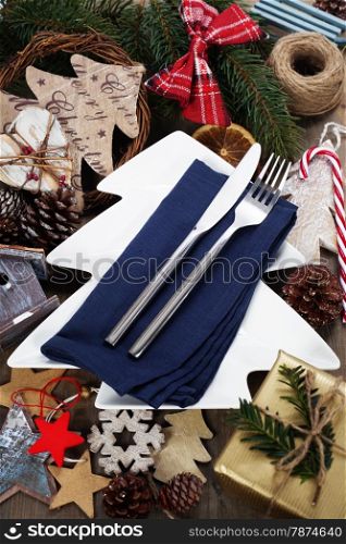 Christmas table place setting with christmas decorations on wooden table