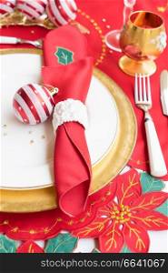 Christmas table with white and golden plate, knife and fork close up. Christmas golden plate