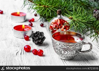 Christmas tea party. Cranberry tea in stylish iron cups at the Christmas background