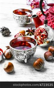 Christmas tea with cranberry. Cranberry tea in stylish cups at the Christmas background