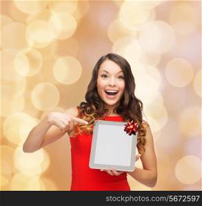 christmas, technology, present and people concept - smiling woman in red dress with blank tablet pc computer screen over beige lights background