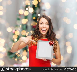 christmas, technology, present and people concept - smiling woman in red dress with blank tablet pc computer screen over living room and christmas tree background