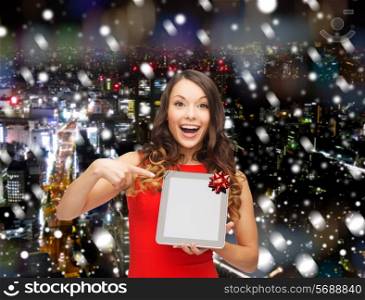 christmas, technology, present and people concept - smiling woman in red dress with blank tablet pc computer screen over snowy night city background