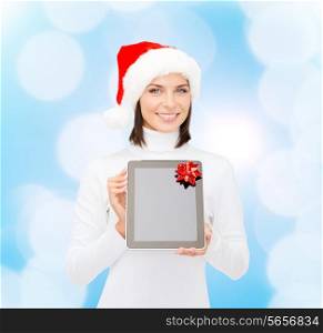 christmas, technology, present and people concept - smiling woman in santa helper hat with blank screen tablet pc computer over blue lights background