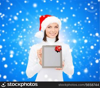 christmas, technology, present and people concept - smiling woman in santa helper hat with blank screen tablet pc computer over blue snowy background