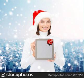 christmas, technology, present and people concept - smiling woman in santa helper hat with blank screen tablet pc computer over snowy city background