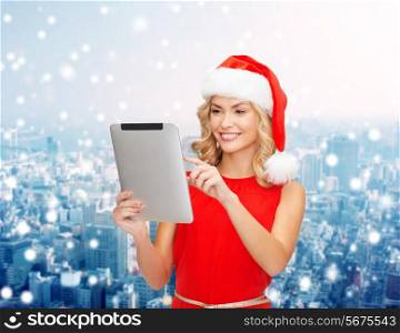 christmas, technology, present and people concept - smiling woman in santa helper hat with tablet pc computer over snowy city background