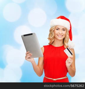 christmas, technology, shopping and people concept - smiling woman in santa helper hat with tablet pc computer and credit card over blue lights background