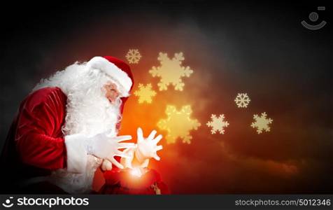 christmas theme with santa. Santa with beard and red hat holding and looking into the sack