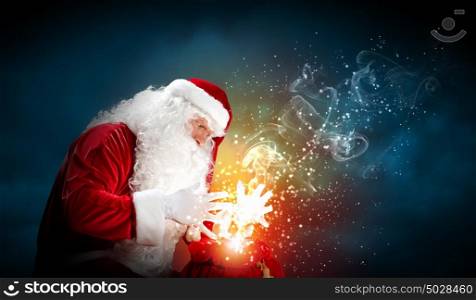 christmas theme with santa. Santa with beard and red hat holding and looking into the sack