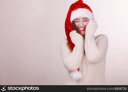 Christmas time. Young smiling lady wearing santa claus hat. Celebration holiday concept.. Woman wearing santa claus hat