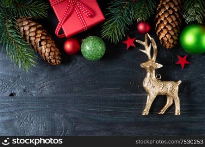 Christmas top view scene with deer and red git boxes, Christmas celebration and gift giving concept, copy space on wooden background. Christmas flat lay scene with golden decorations