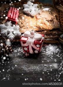Christmas toys in form of gift and winter decorations on rustic wooden background. Greeting card
