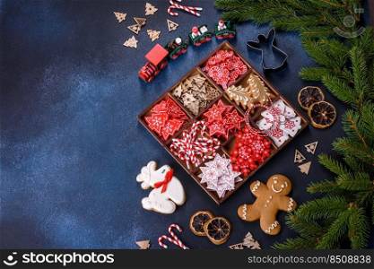 Christmas toys in white and red in a wooden sectional box against a dark concrete background. Home decorations for Christmas holiday. Christmas toys in white and red in a wooden sectional box against a dark concrete background