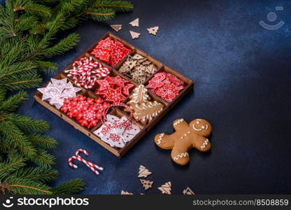 Christmas toys in white and red in a wooden sectional box against a dark concrete background. Home decorations for Christmas holiday. Christmas toys in white and red in a wooden sectional box against a dark concrete background