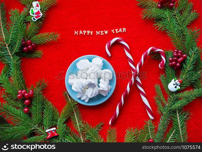 Christmas tree and candy on a red background with the words Happy New Year.. Christmas tree and candy on a red background with the words Happy New Year